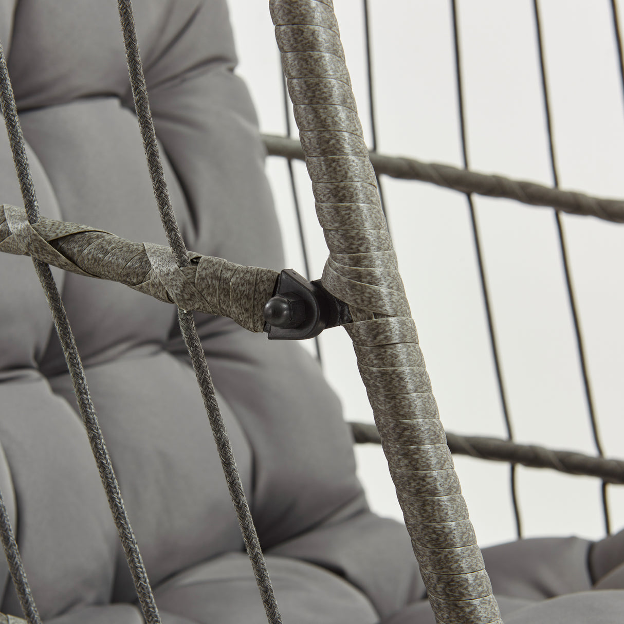 Silla colgante tipo huevo de ratán gris con cojines acolchados, estructura de metal y detalles en cuerda trenzada, ideal para interiores y exteriores