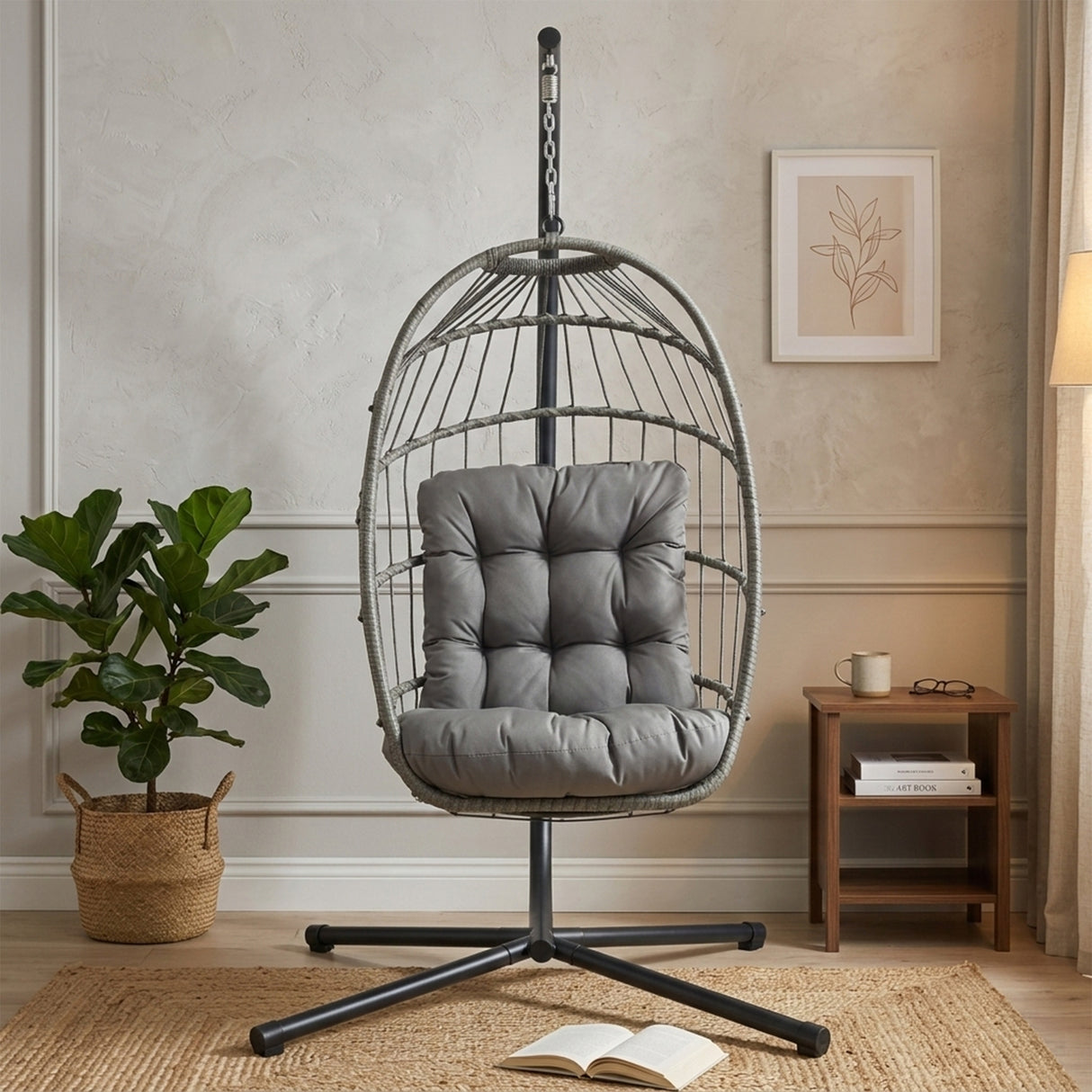 Silla colgante tipo huevo de ratán gris con cojín suave, estructura metálica negra, ideal para decoración moderna y comodidad en interiores