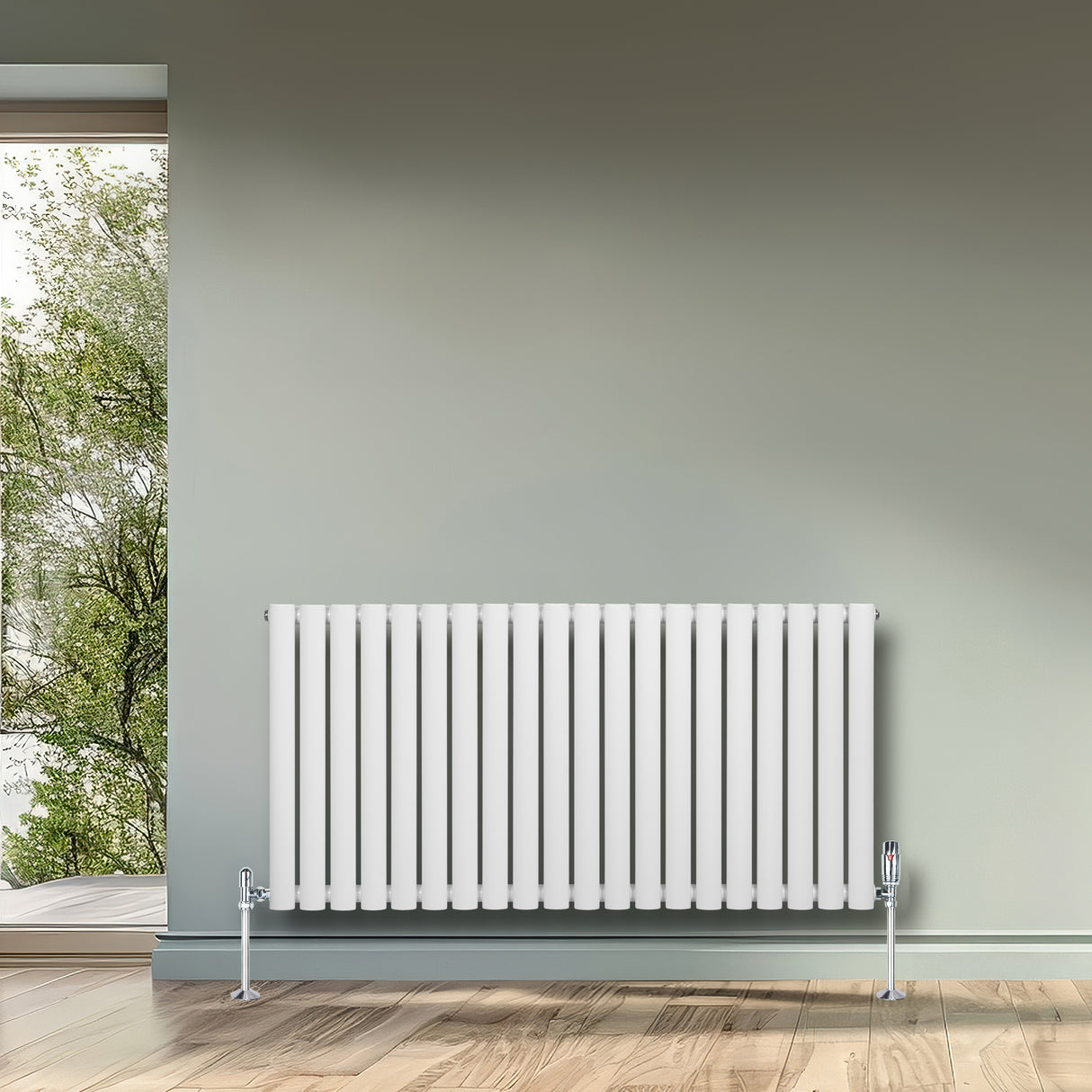 Radiador de columna ovalado blanco de 600 mm x 1200 mm, con válvulas, instalado en una pared gris junto a una ventana con vista al exterior