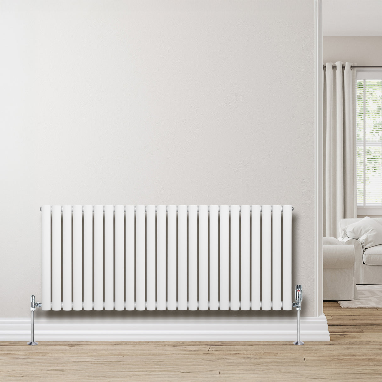 Radiador de columna ovalado blanco de 600 mm x 1440 mm, con válvulas, instalado en una pared clara, complementando un ambiente moderno y acogedor