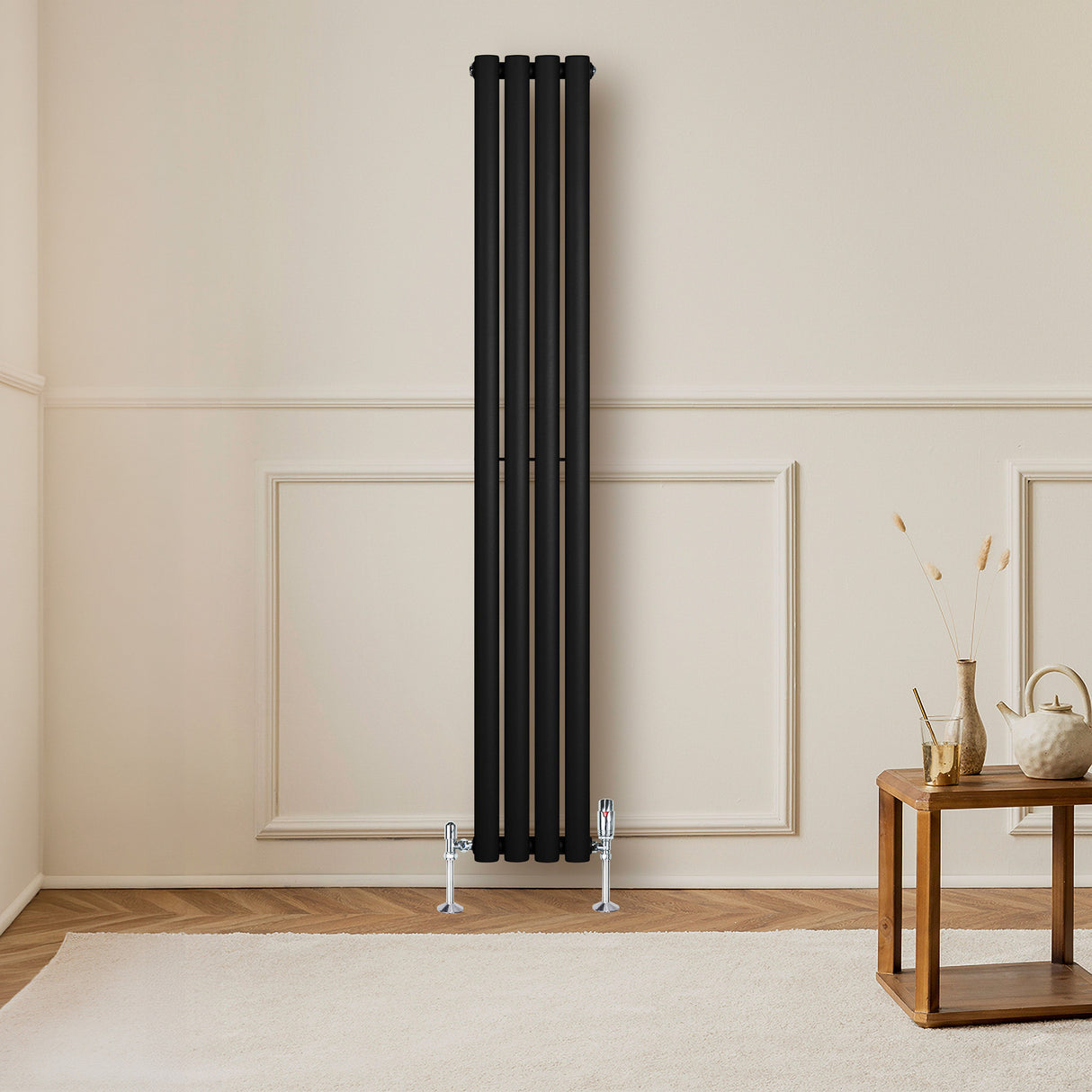 Radiador de columna ovalado negro de 1600 mm x 240 mm, instalado en pared clara, con válvulas metálicas en la base y suelo de madera clara