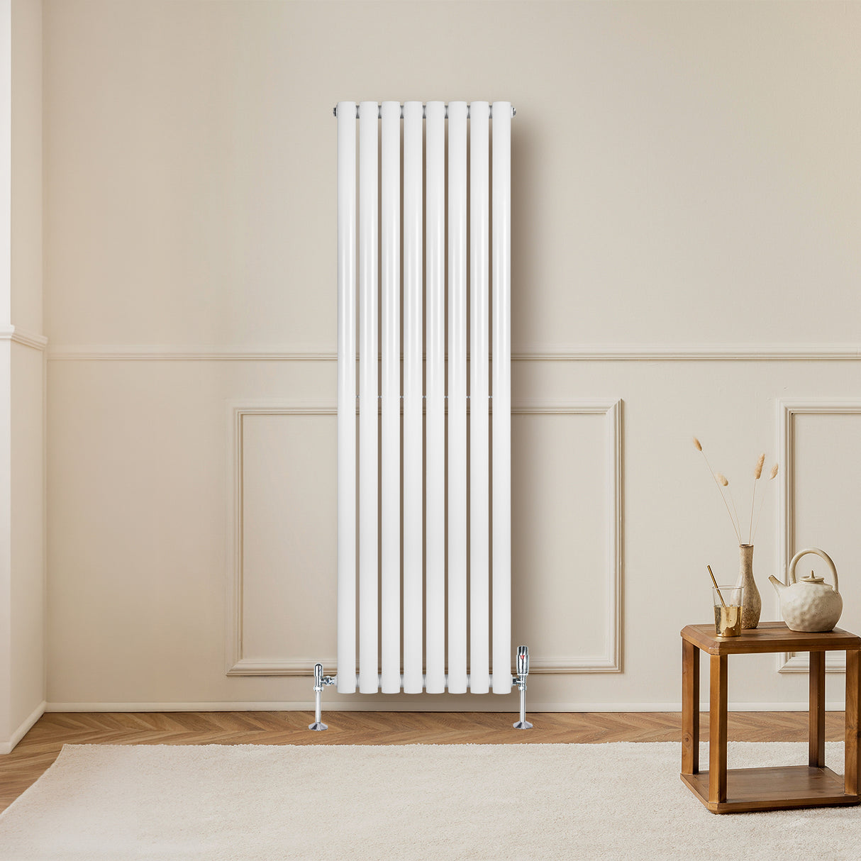 Radiador de columna ovalado blanco de 1600 mm x 480 mm, con válvulas, instalado en una pared clara junto a una mesa de madera