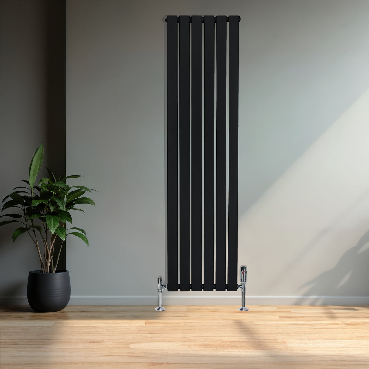 Radiador plano de columna simple negro de 1600 x 420 mm con válvulas, instalado en una pared junto a una planta decorativa