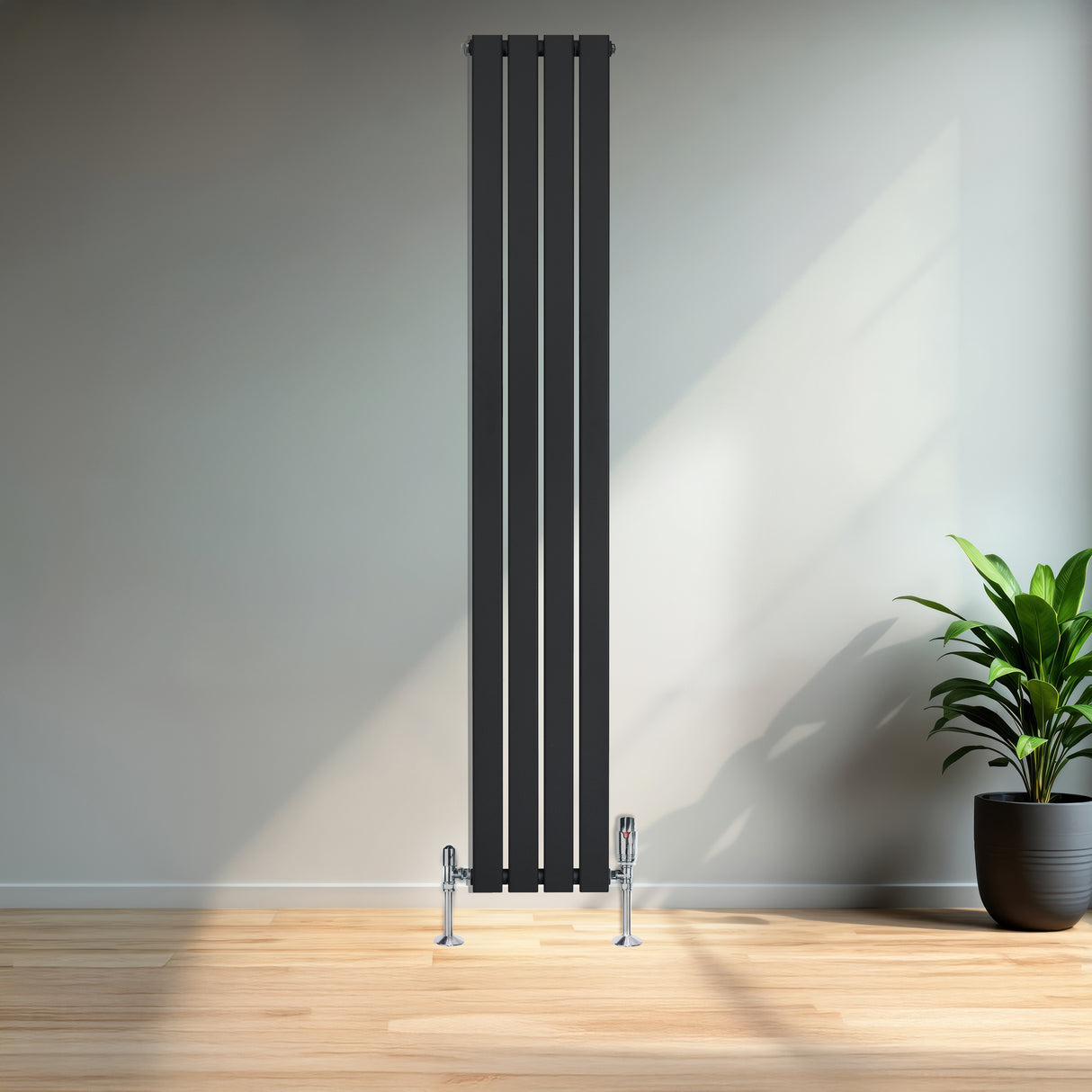 Radiador plano de columna simple negro de 1800 mm x 280 mm, con válvulas, instalado en una pared clara junto a una planta decorativa