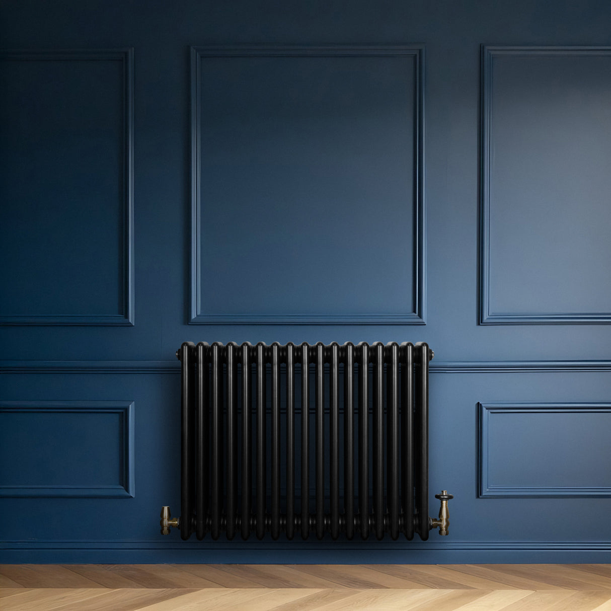 Radiador tradicional negro de 4 columnas con válvulas, instalado en una pared azul, con un acabado liso y elegante en un ambiente moderno