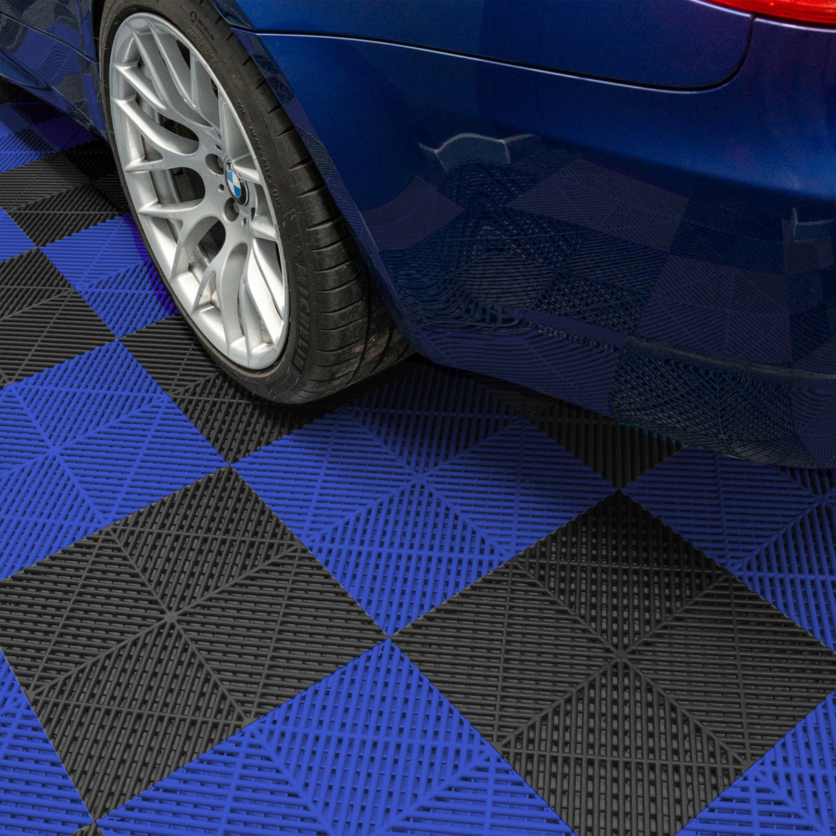 Baldosas de polipropileno en negro y azul con canales de ventilación, ideales para garajes, con textura antideslizante y diseño modular