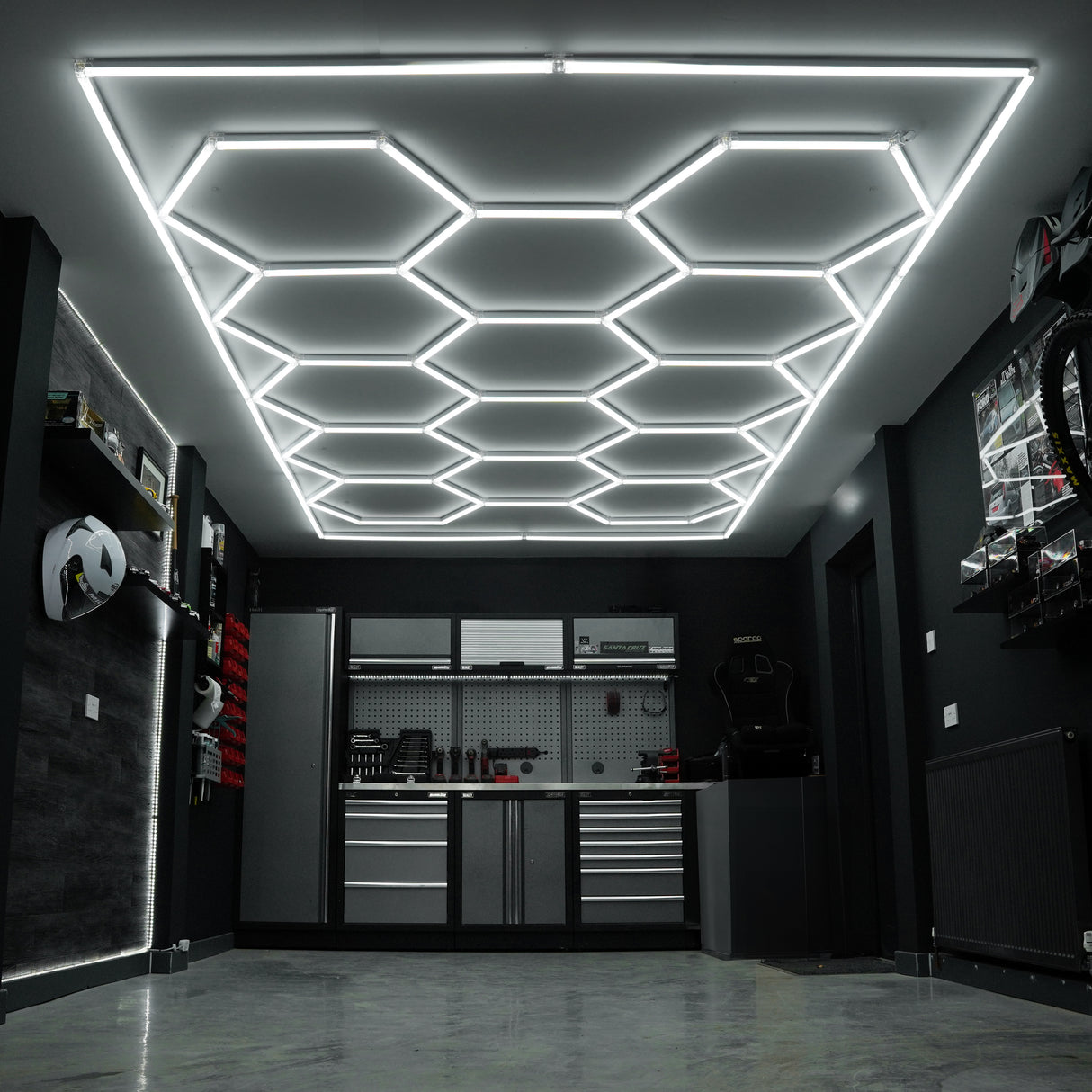 Baldosas de polipropileno azul y gris en un garaje moderno, con luz LED hexagonal brillante en el techo y muebles organizados