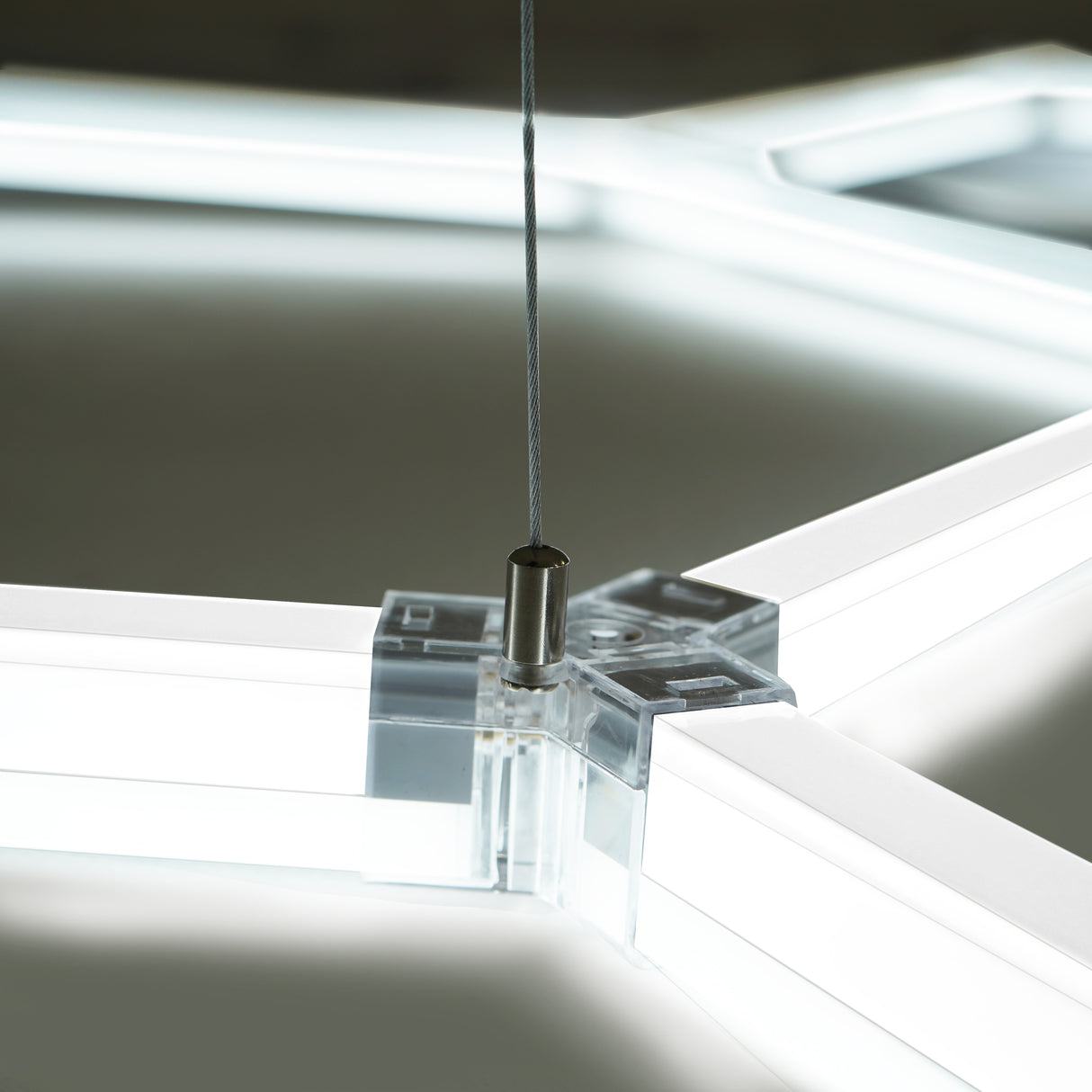 Luz LED hexagonal de techo con bordes transparentes y cable de suspensión, ideal para decoración moderna y funcional en espacios interiores