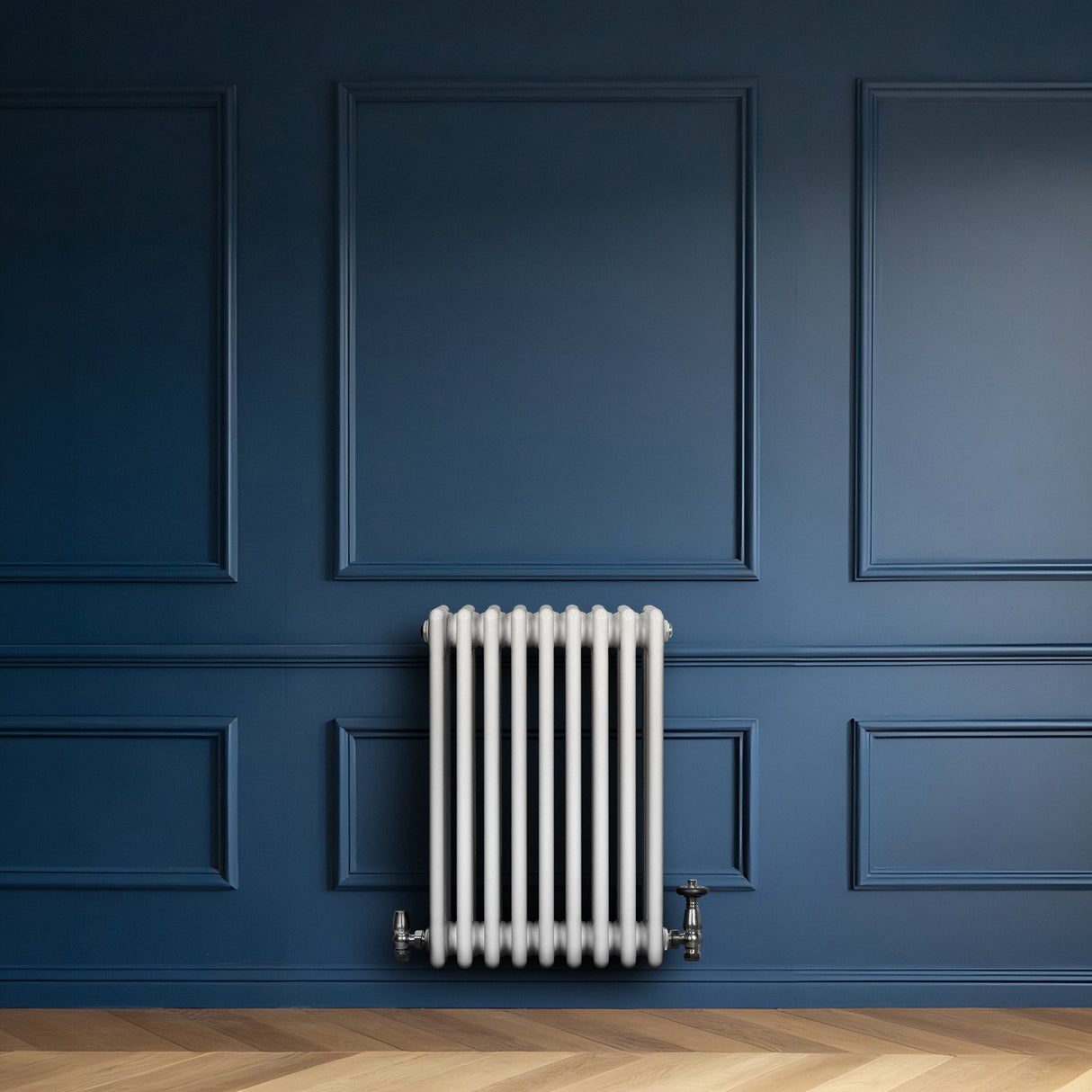 Radiador tradicional de 4 columnas en color blanco, instalado en una pared azul, con un diseño clásico y acabado liso