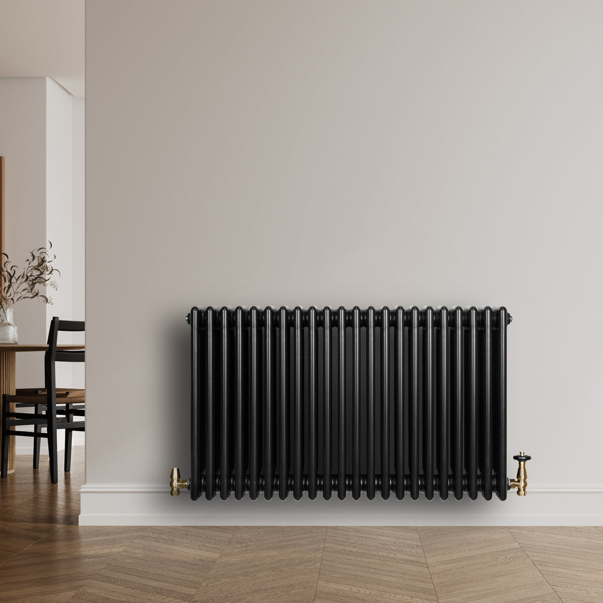 Radiador tradicional de 4 columnas en color negro, con acabado brillante y grifos dorados, instalado en una pared clara