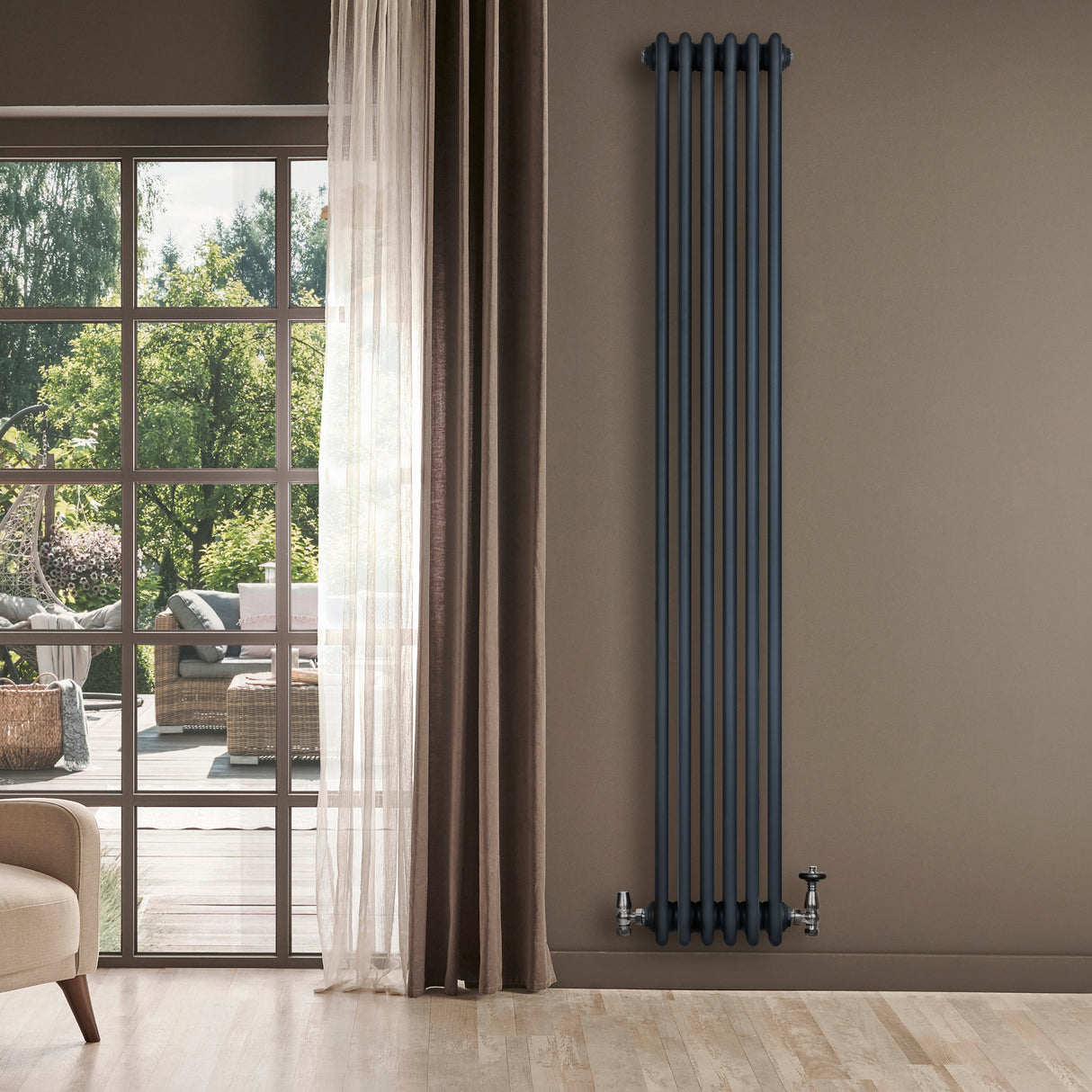 Radiador tradicional de 4 columnas en gris antracita, elegante y alto, instalado en una pared junto a una ventana con luz natural