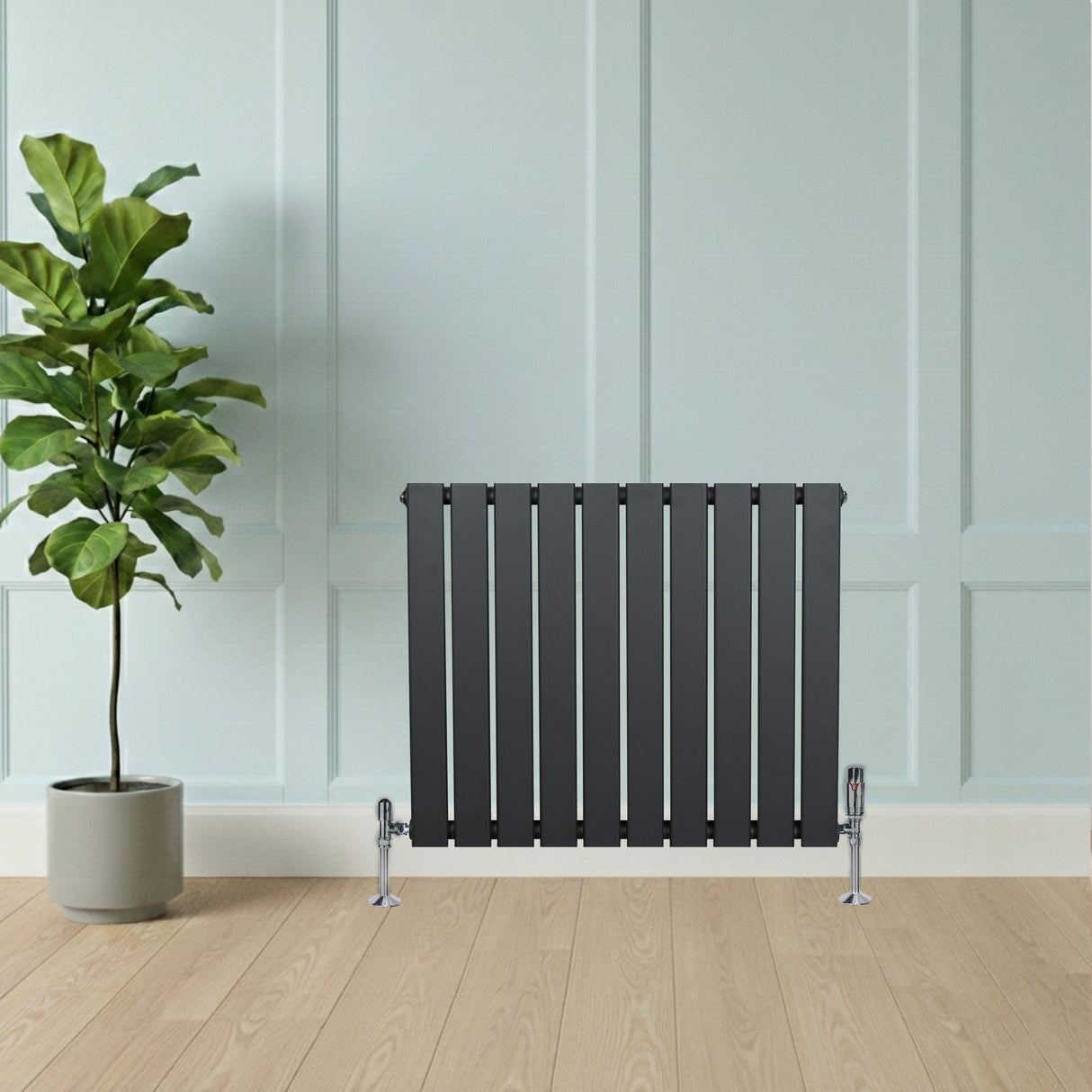 Radiador de columna única gris antracita de 600 mm x 700 mm, con diseño moderno y acabado liso, junto a una planta en maceta