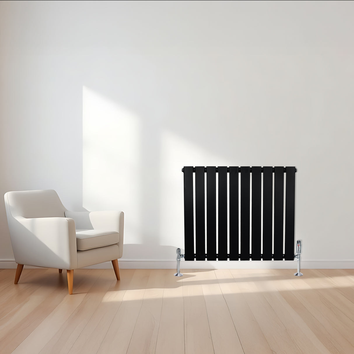 Radiador de columna única negro de 600 mm x 700 mm, con diseño moderno y acabado liso, ubicado junto a una silla blanca en un ambiente luminoso