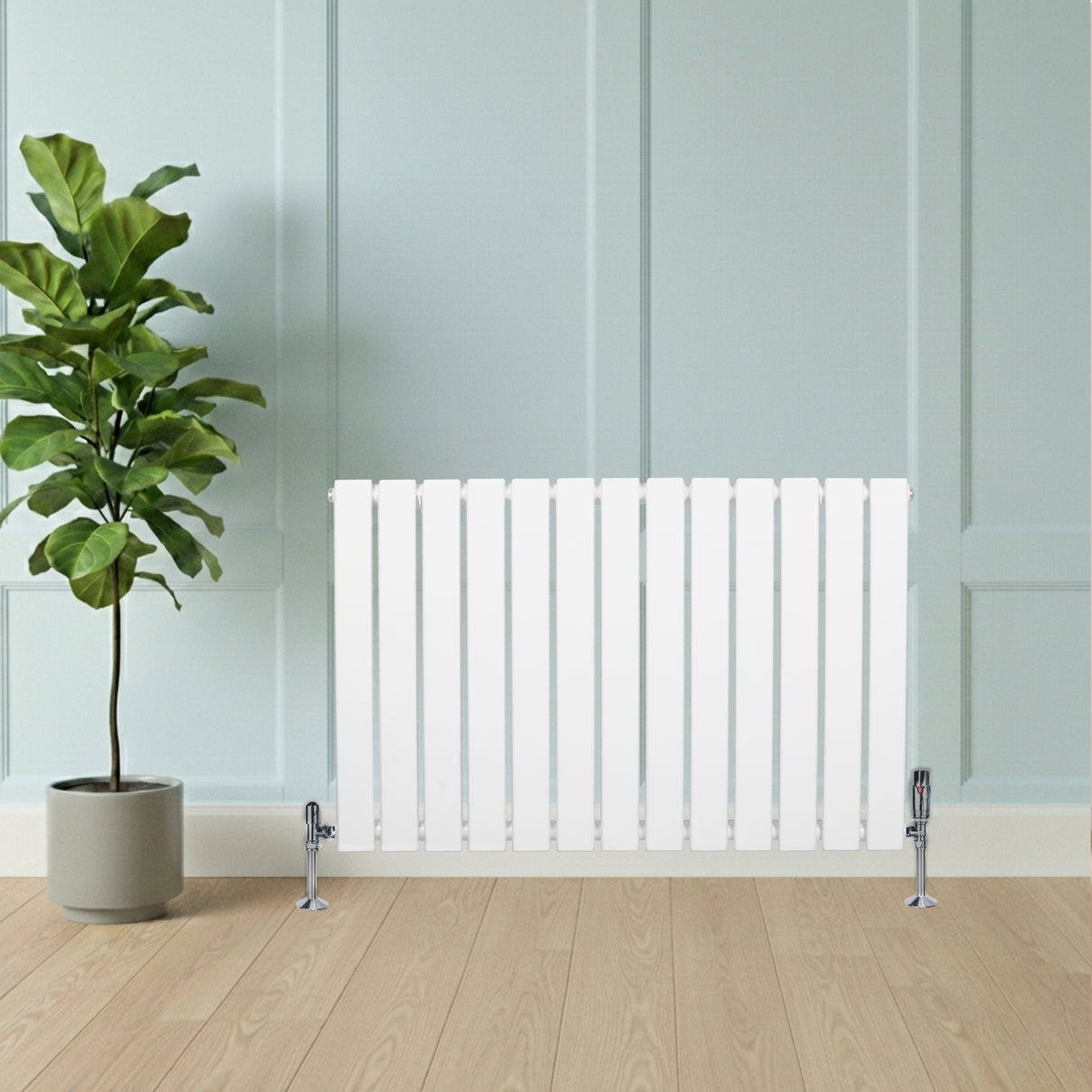 Radiador de columna única blanco de 600 mm x 910 mm, con diseño moderno y acabado liso, instalado junto a una planta verde en maceta