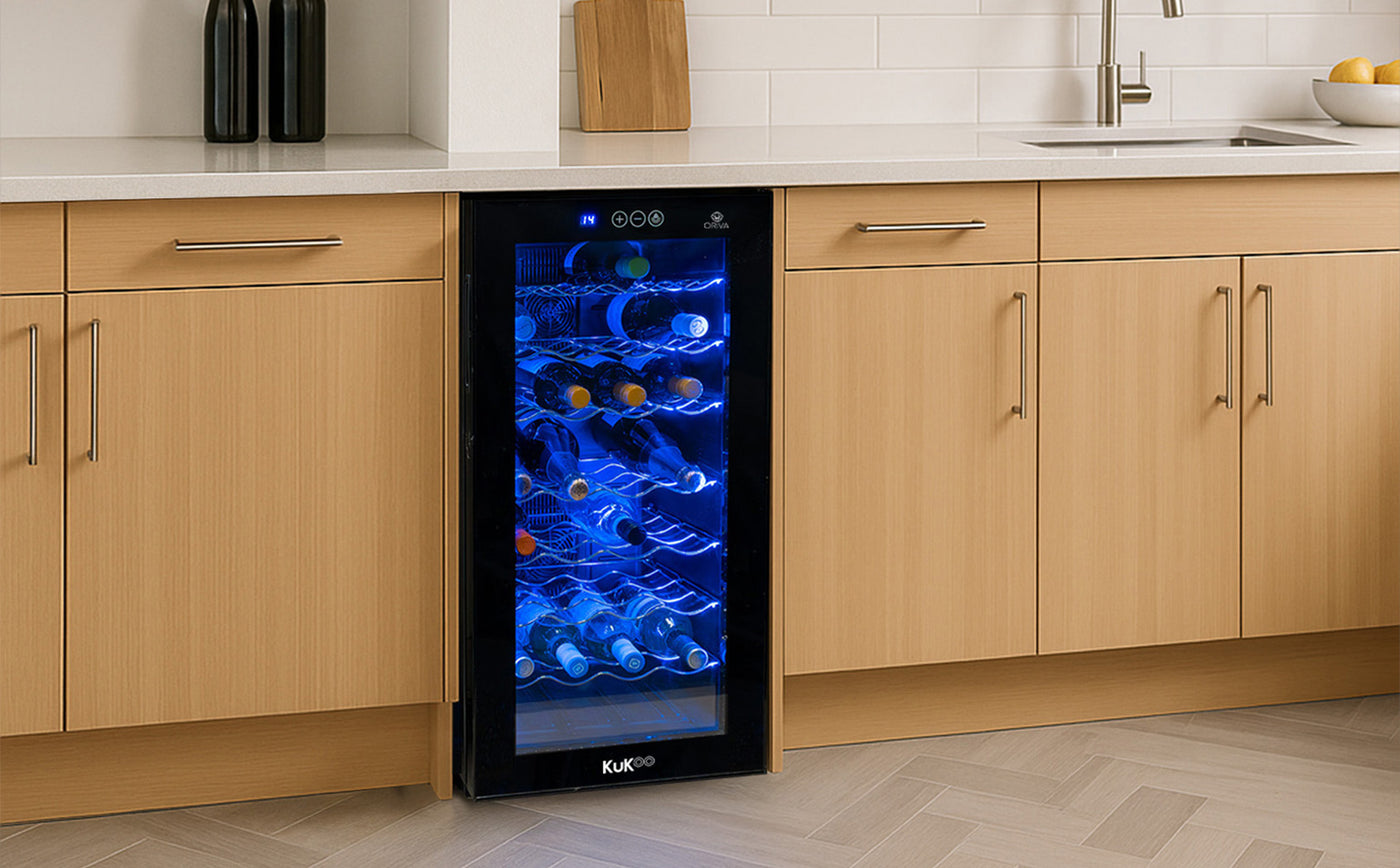 Vinoteca KUKKO con luz azul, puertas de vidrio, estantes metálicos, ubicada en una cocina moderna con muebles de madera clara