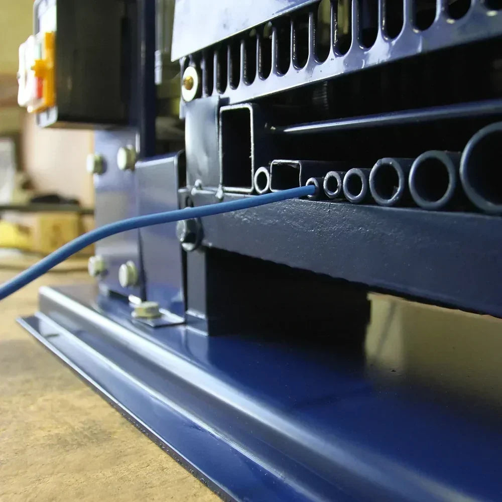 Pelacables T-Mech en color azul oscuro, mostrando detalles de su diseño y ranuras para cables en un entorno de trabajo industrial