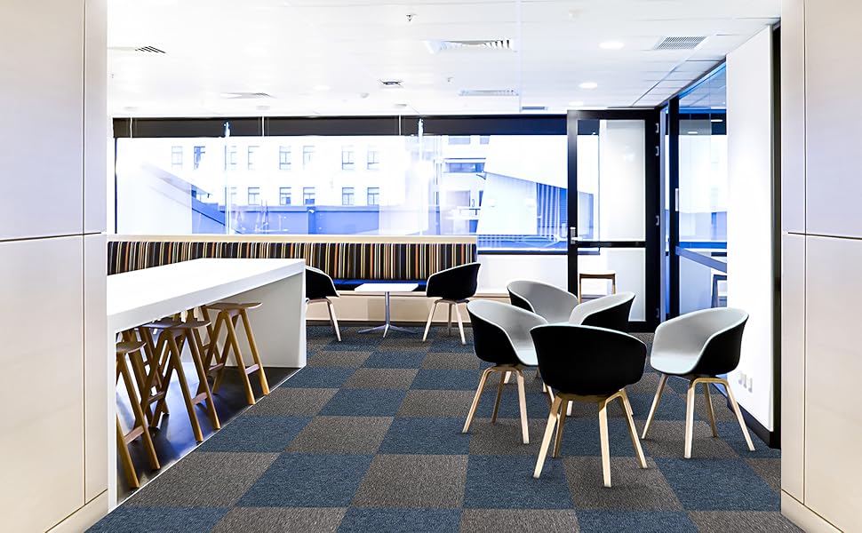 Losetas de moqueta en tonos gris y azul, con textura suave, en un moderno espacio de oficina con muebles minimalistas y luminoso ambiente