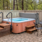 Cubierta gris para jacuzzi de 2,2m x 2,2m, con textura suave, que protege el jacuzzi en un entorno natural y relajante