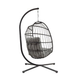 Silla colgante tipo huevo de ratán negro con estructura metálica y cojín gris suave, ideal para interiores y exteriores