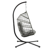 Silla colgante tipo huevo de ratán gris, con estructura metálica negra y cojín suave, ideal para relajarse en interiores o exteriores