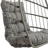 Silla colgante tipo huevo de ratán en gris, con cojín acolchado y estructura de cuerda trenzada, ideal para interiores y exteriores