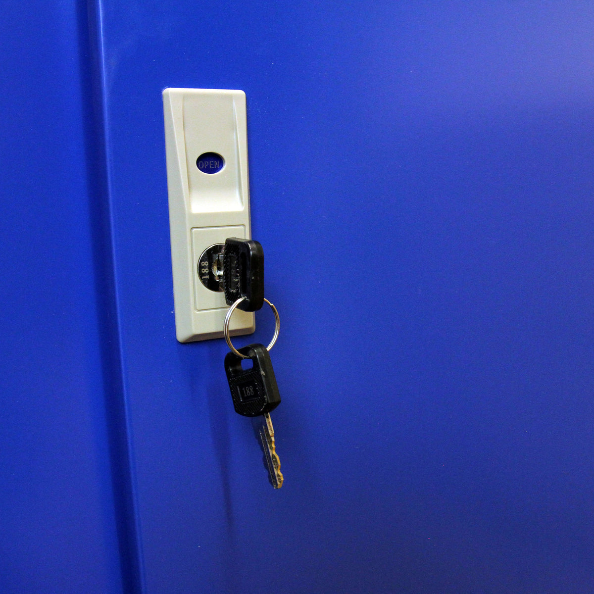 Llave colgando de un candado en un mueble expositor azul para cigarrillos y vapeadores, con un botón de apertura visible
