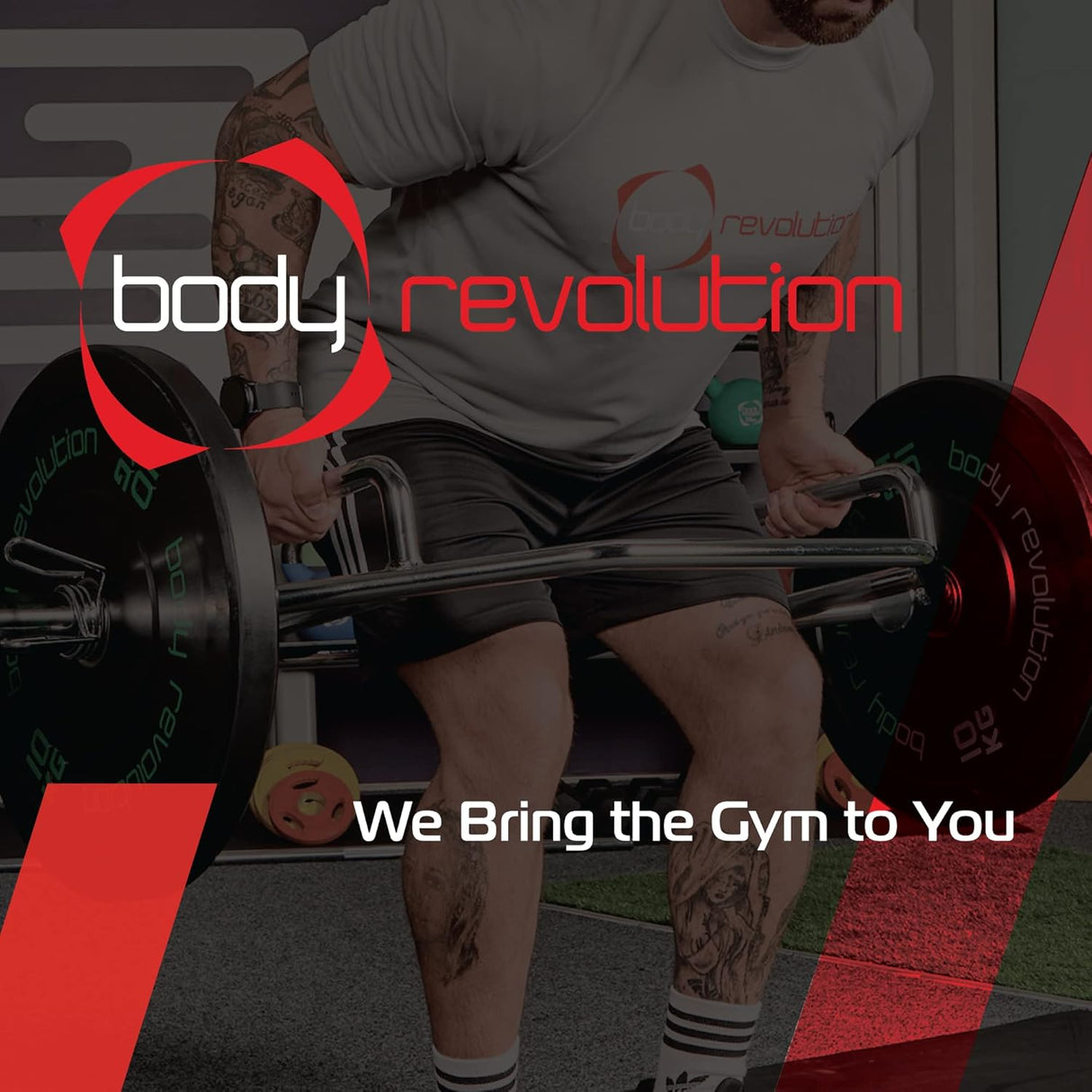 Hombre levantando una barra T-Bar en un gimnasio, con camiseta gris y pantalones cortos, fondo moderno y equipo de entrenamiento brillante