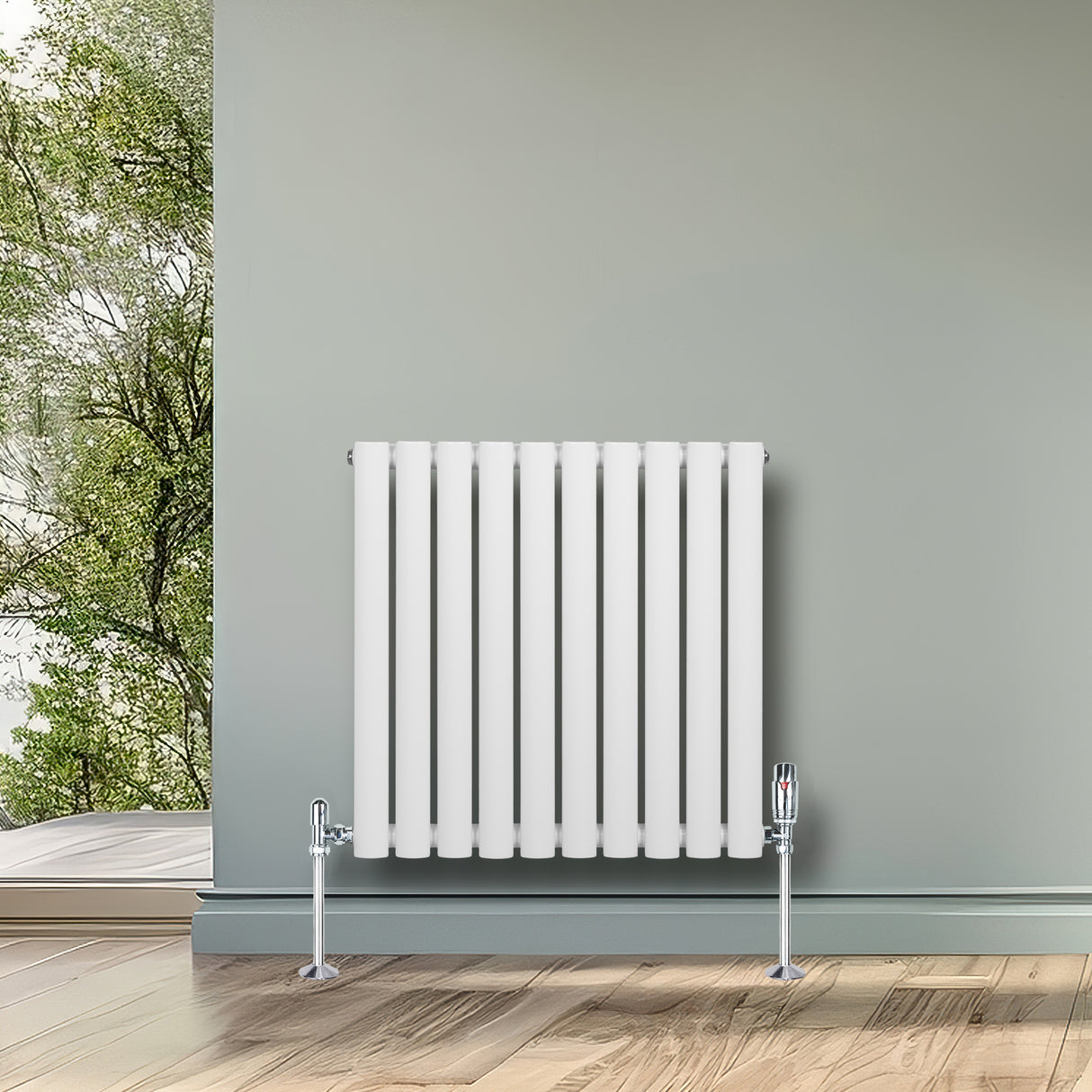 Radiador de columna ovalado blanco de 600 mm x 600 mm con válvulas, instalado en una pared junto a una ventana con vista al exterior