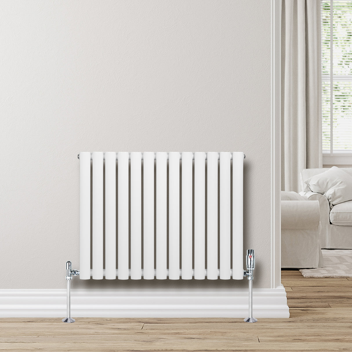 Radiador de columna ovalado blanco de 600 mm x 780 mm con válvulas, instalado en una pared clara, complementando un ambiente moderno y acogedor