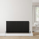 Radiador de columna ovalado negro de 600 mm x 1200 mm, con válvulas, instalado en una pared clara, complementando un ambiente moderno y luminoso