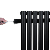 Radiador de columna ovalado negro de 600 mm x 1440 mm, con válvulas, siendo limpiado con un cepillo en la parte superior
