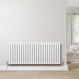 Radiador de columna ovalado blanco de 600 mm x 1440 mm, con válvulas, instalado en una pared clara, complementando un ambiente moderno y acogedor