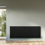 Radiador de columna ovalado negro de 600 mm x 1620 mm, con válvulas, instalado en pared junto a ventana con vista al exterior
