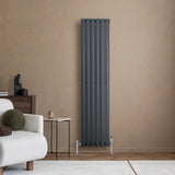 Radiador de columna ovalado gris antracita de 1600 mm x 360 mm, con válvulas, instalado en pared de color beige, junto a muebles modernos