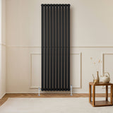 Radiador de columna ovalado negro de 1800 mm x 600 mm con válvulas, elegante diseño vertical y acabado mate en un ambiente moderno