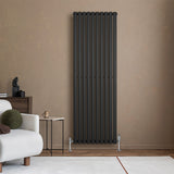 Radiador de columna ovalado negro de 1800 mm x 600 mm, con válvulas, instalado en una pared de tonos tierra, elegante y moderno