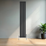 Radiador plano de columna simple negro de 1800 mm x 280 mm, con válvulas, instalado en una pared clara junto a una planta decorativa