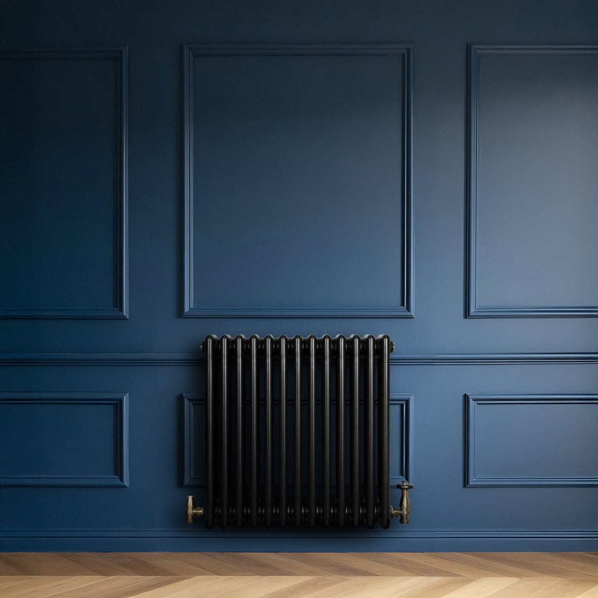 Radiador tradicional de 4 columnas en color negro, instalado en una pared azul, con válvulas doradas y textura metálica brillante