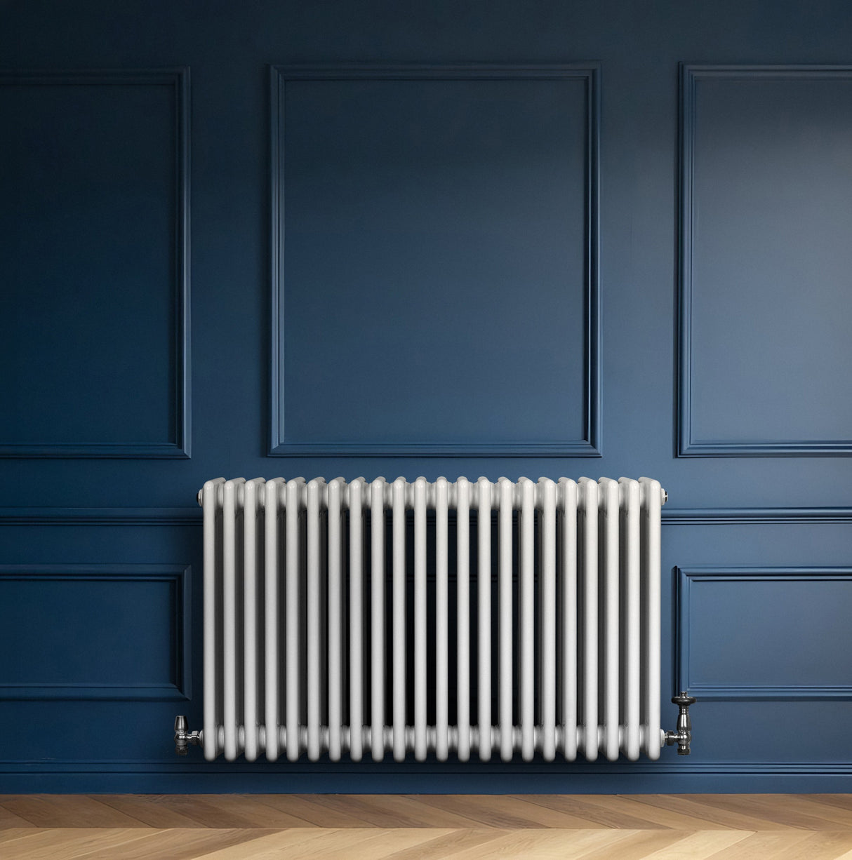 Radiador tradicional de 4 columnas en color blanco, con válvulas, instalado en una pared azul, destacando su diseño elegante y moderno