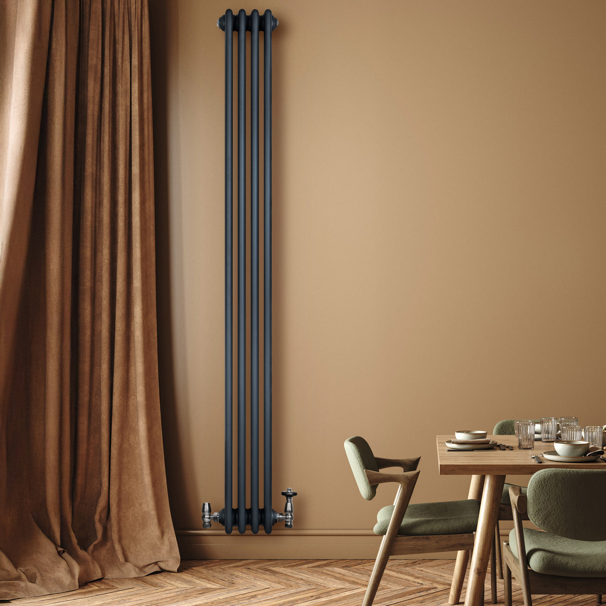 Radiador tradicional de 4 columnas en gris antracita, instalado en pared beige, junto a una mesa de comedor y cortinas marrones