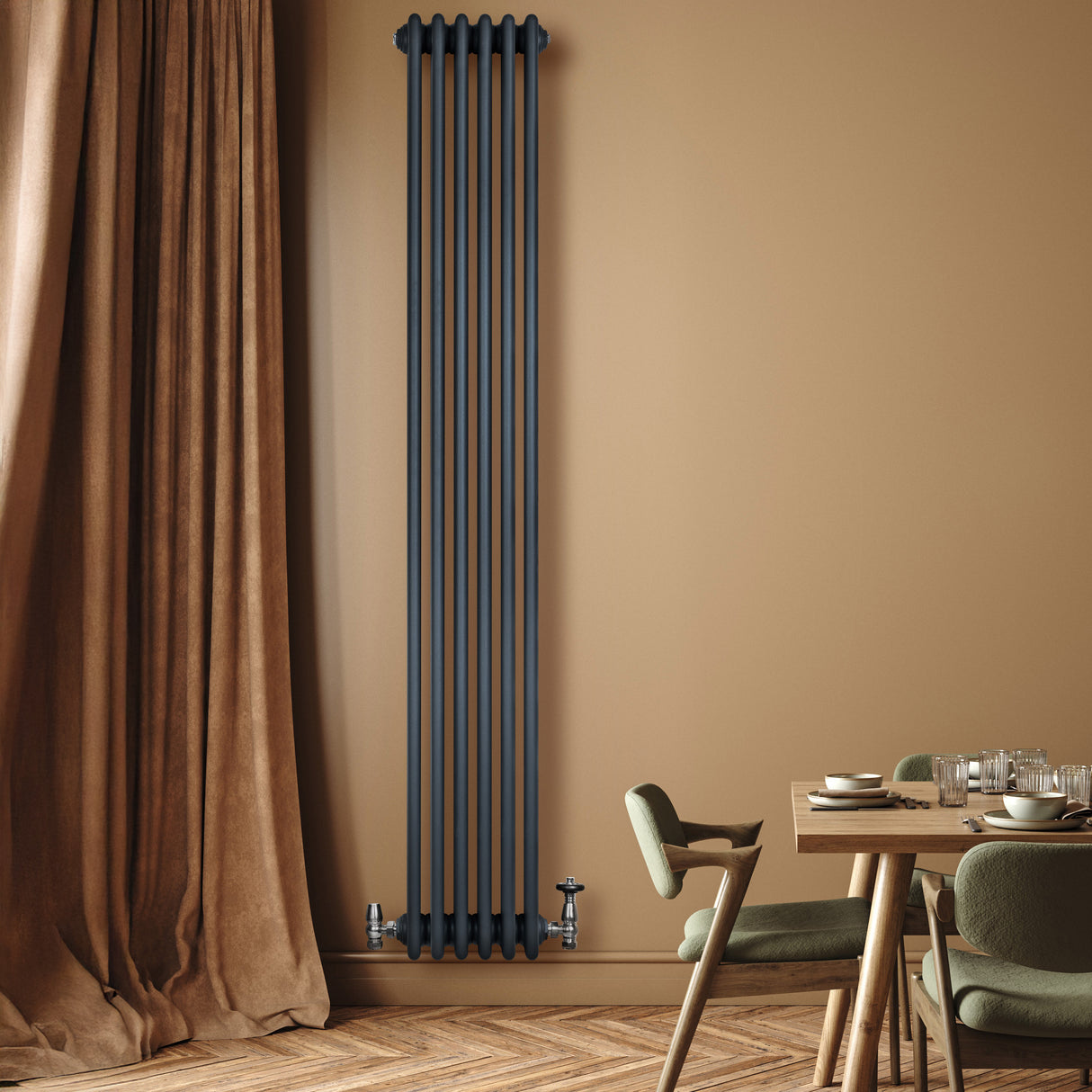 Radiador tradicional de 4 columnas en gris antracita, instalado en una pared beige, junto a una mesa de comedor y cortinas marrones