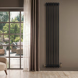 Radiador tradicional negro de 4 columnas, 1800 x 380 mm, con válvulas, instalado en una pared junto a una ventana luminosa