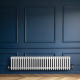 Radiador tradicional de 4 columnas en color blanco, instalado en una pared azul, con un diseño elegante y acabado liso