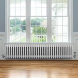 Radiador tradicional de 4 columnas en color blanco, con un diseño elegante y acabado liso, instalado bajo una ventana amplia