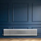 Radiador tradicional de 4 columnas en color blanco, instalado en una pared azul, con un acabado liso y elegante, ideal para calefacción