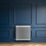 Radiador tradicional de 4 columnas en color blanco, con un diseño elegante, instalado en una pared azul con paneles decorativos
