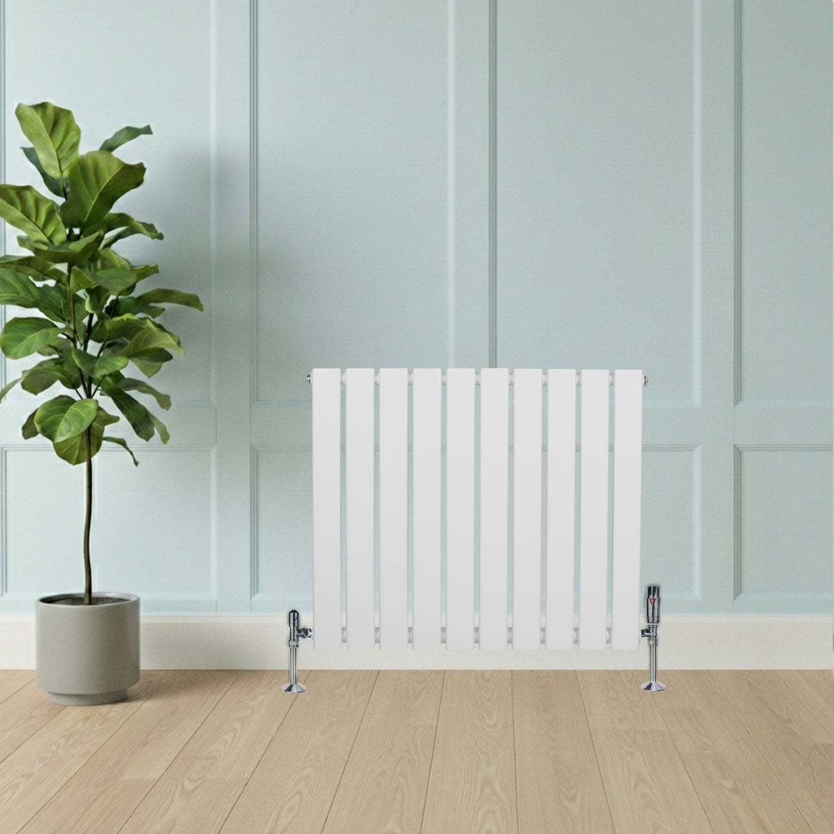 Radiador de columna única blanco de 600 mm x 700 mm, con diseño moderno y acabado liso, instalado en pared junto a planta decorativa
