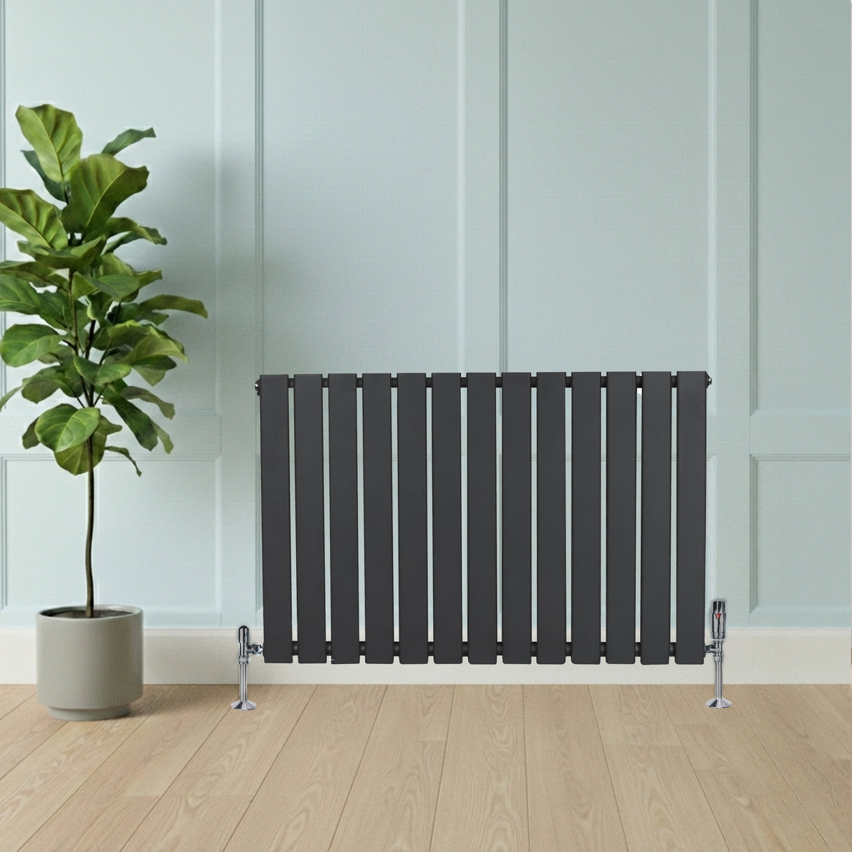 Radiador de columna única gris antracita de 600 mm x 910 mm, con diseño moderno y acabado liso, junto a una planta en maceta