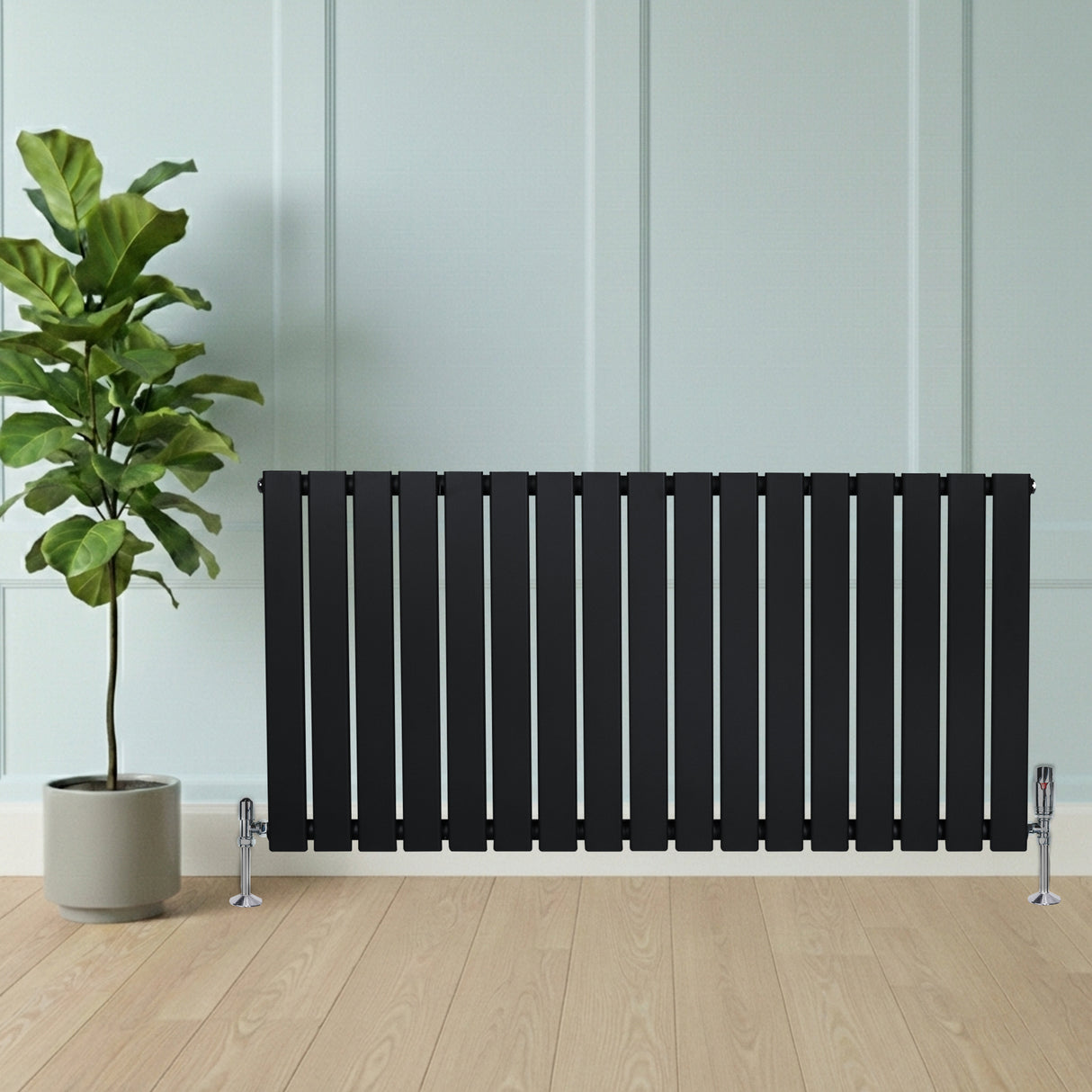 Radiador de columna única negro de 600 mm x 1190 mm, con diseño elegante y moderno, colocado junto a una planta en maceta sobre suelo de madera clara