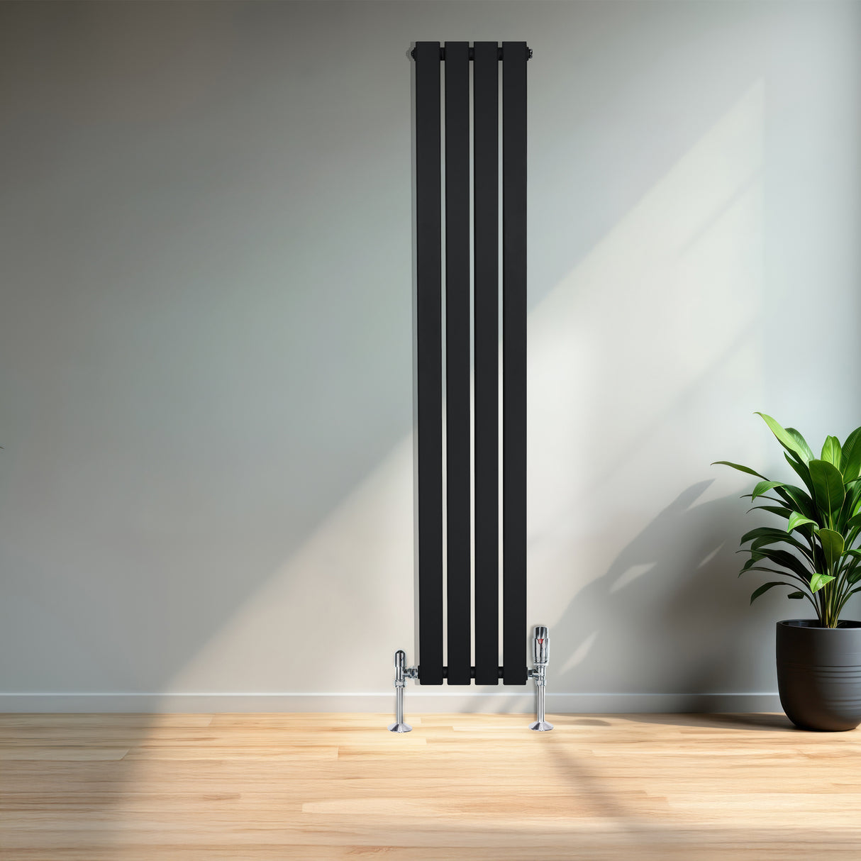 Radiador de columna única negro de 1600 mm x 280 mm, con diseño moderno y acabado liso, instalado en una pared clara junto a una planta decorativa